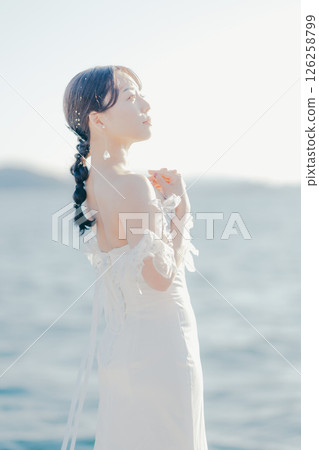 身穿婚紗的女子站在海灘背光下的肖像 126258799