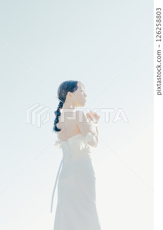 身穿婚紗的女子站在海灘背光下的肖像 126258803