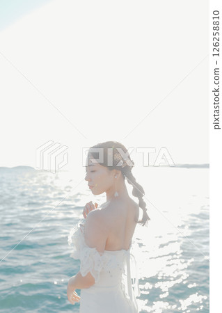 身穿婚紗的女子站在海灘背光下的肖像 126258810