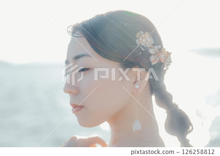 身穿婚紗的女子站在海灘背光下的肖像 身穿婚紗的女子站在海灘背光下的肖像 126258812