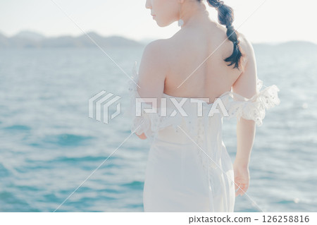 身穿婚紗的女子站在海灘背光下的肖像 126258816