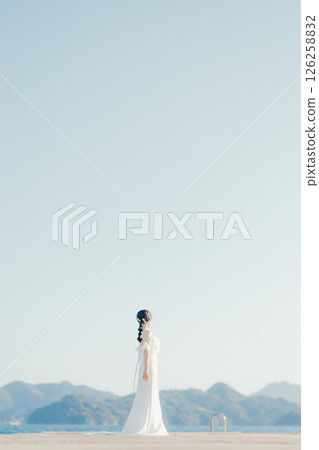 身穿婚紗的女子站在海灘背光下的肖像 126258832