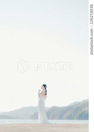 身穿婚紗的女子站在海灘背光下的肖像 126258836