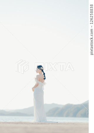 身穿婚紗的女子站在海灘背光下的肖像 126258838
