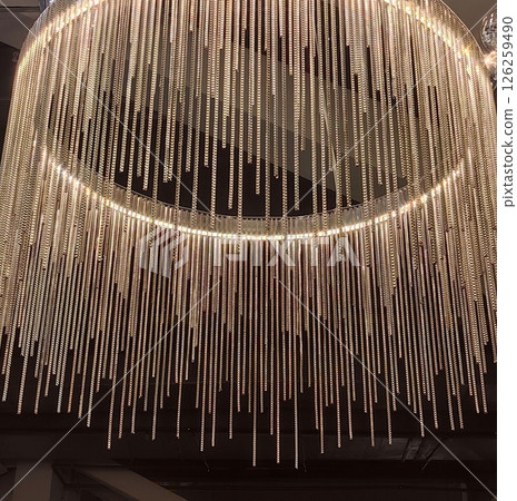 elegant chandelier with cascading crystal strands enhancing modern interior decor. close up. 126259490