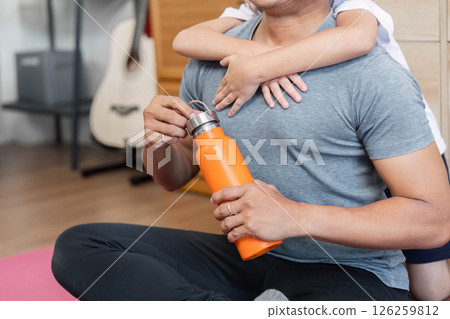 Family love captured with son hugging father during workout break Family love captured with son hugging father during workout break 126259812