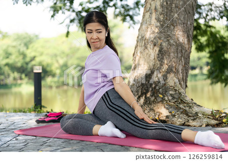 Wellness and Flexibility. Woman practicing yoga pose outdoors for health. 126259814