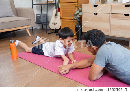 Family fitness activity with father and son playing on exercise mat 126259845