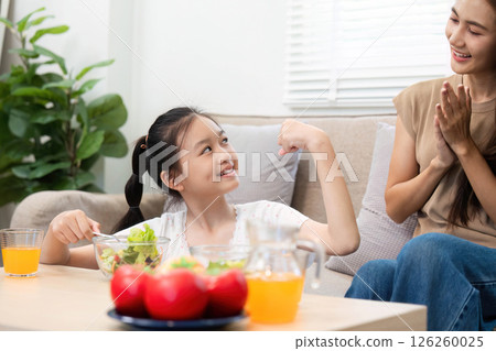 Wellness and strength Daughter showing muscles with mothers support Wellness and strength Daughter showing muscles with mothers support 126260025