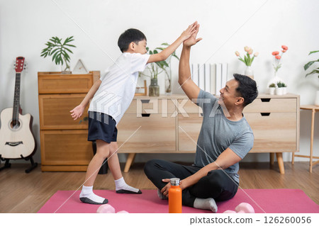 Family connection: Father and son high-five after workout 126260056
