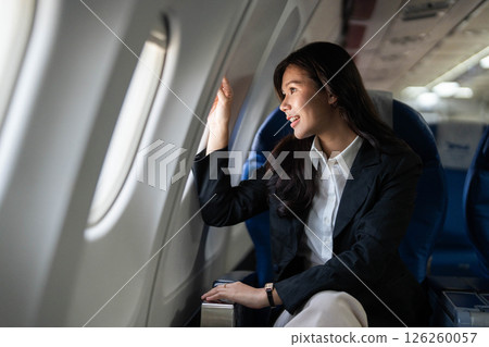 Business travel with woman looking out of an airplane window 126260057