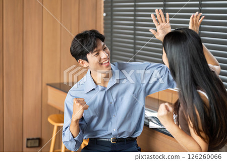 Joyful Business Interaction. Two colleagues celebrating a successful idea in a contemporary office. Joyful Business Interaction. Two colleagues celebrating a successful idea in a contemporary office. 126260066