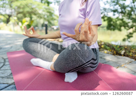 Wellness and Meditation. Woman meditating outdoors in a yoga pose. 126260087