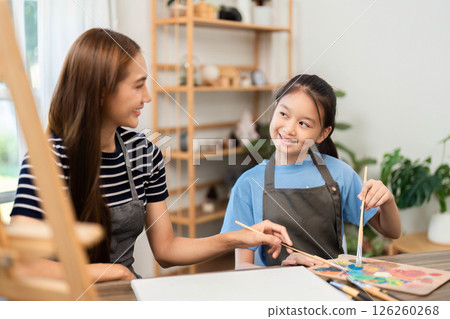 Artistic bonding: Woman and girl exploring creativity with paints 126260268