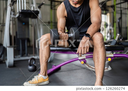 Fitness Journey: Young Man Performing Dumbbell Curl at Gym Fitness Journey: Young Man Performing Dumbbell Curl at Gym 126260274