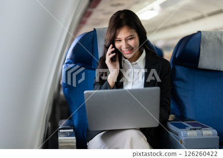Business travel with professional woman using laptop on an airplane 126260422