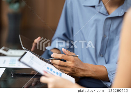 Business Analysis and Strategy. Professionals reviewing financial reports in a contemporary office. 126260423