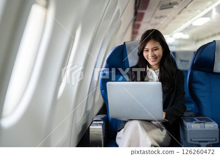 Business travel efficiency with a woman working on a laptop in-flight 126260472