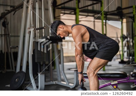 Fitness Commitment: Young Man Performing Kettlebell Lifts Fitness Commitment: Young Man Performing Kettlebell Lifts 126260492
