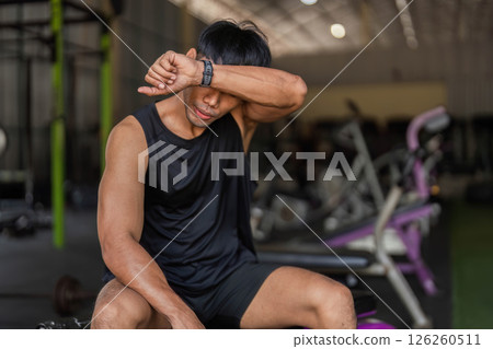 Post-Workout Reflection: Young Man in Gym After Kettlebell Session Post-Workout Reflection: Young Man in Gym After Kettlebell Session 126260511