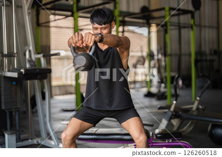 Kettlebell Workout. Man lifting kettlebell in gym for functional fitness and strength. Kettlebell Workout. Man lifting kettlebell in gym for functional fitness and strength. 126260518