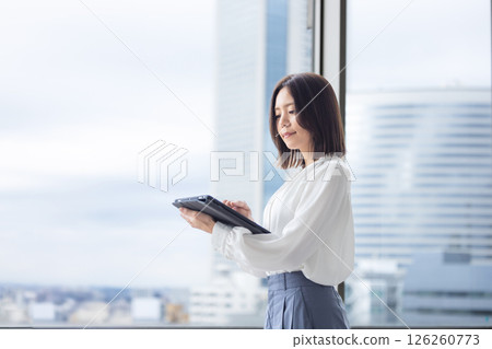 Woman operating a tablet in the office Woman operating a tablet in the office 126260773