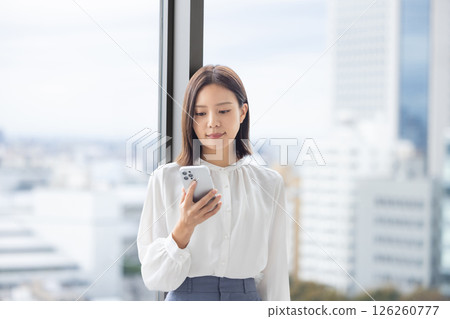 一個操作智能手機的年輕女子 126260777