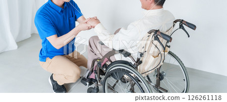 男性護理人員和坐輪椅的老人 男性護理人員和坐輪椅的老人 126261118