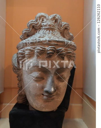 A Buddha head with wavy hair on display at a museum in Peshawar, the capital of Gandhara. A Buddha head with wavy hair on display at a museum in Peshawar, the capital of Gandhara. 126262110