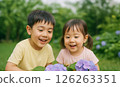 Smiling children gazing at hydrangeas and snails 126263351