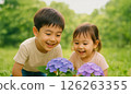 Smiling children gazing at hydrangeas and snails 126263355