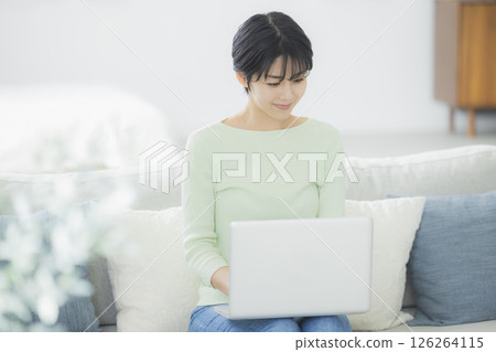 一位女士在客廳使用電腦 126264115