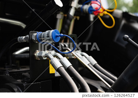 Close-up of hydraulic hoses and connectors on machinery equipment. Close-up of hydraulic hoses and connectors on machinery equipment. 126264527