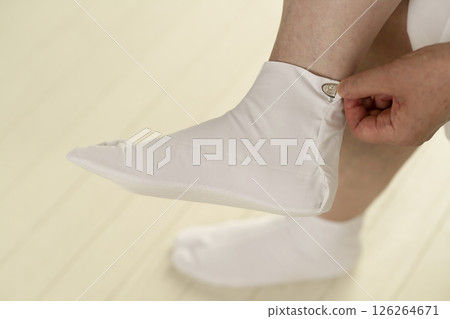 Steps for putting on a kimono: Putting on the tabi socks and fastening the kohaze Steps for putting on a kimono: Putting on the tabi socks and fastening the kohaze 126264671