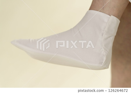 Steps for putting on a kimono: Putting on the tabi socks and fastening the kohaze Steps for putting on a kimono: Putting on the tabi socks and fastening the kohaze 126264672