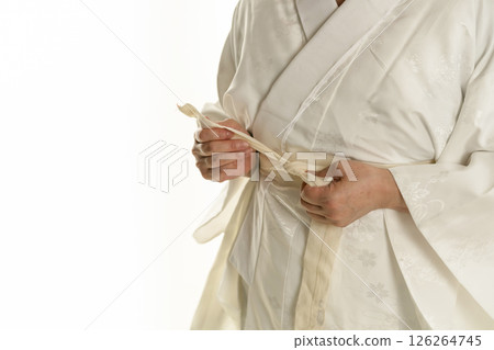 Steps for putting on a Japanese kimono: Inserting a collar stiffener into the collar of the undergarment Steps for putting on a Japanese kimono: Inserting a collar stiffener into the collar of the undergarment 126264745
