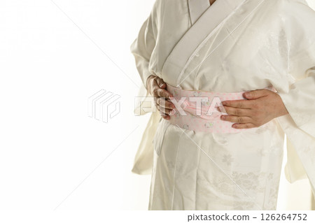 Steps for putting on a Japanese kimono: Inserting a collar stiffener into the collar of the undergarment Steps for putting on a Japanese kimono: Inserting a collar stiffener into the collar of the undergarment 126264752