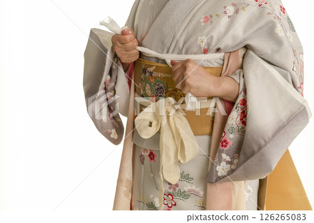 Steps for putting on a kimono: Tightening the obi Steps for putting on a kimono: Tightening the obi 126265083