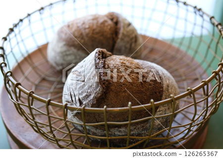 Fresh loaves of bread and buns in rustic bakery, baked goods on rustic background and countryside food market concept Fresh loaves of bread and buns in rustic bakery, baked goods on rustic background and countryside food market concept 126265367