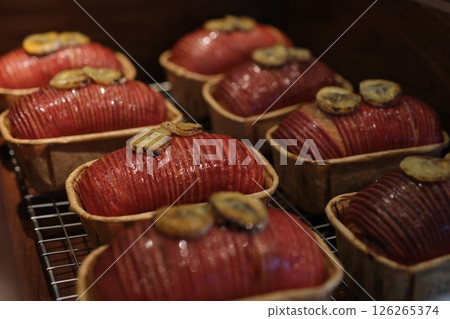 red size puff pastry canapes topped with savory mousse and a dollop of red jam, arranged in rows for a catered event or gourmet buffet. 126265374