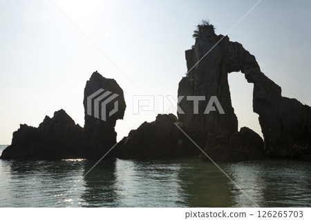 A small rock island with oddly shaped rocks on the sea A small rock island with oddly shaped rocks on the sea 126265703