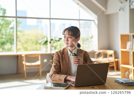 A woman gazing into the distance while working A woman gazing into the distance while working 126265796