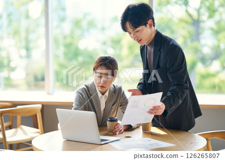Two people checking the contents of the document 126265807