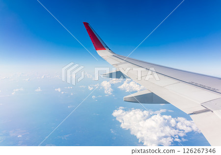 View from the airplane window at a beautiful cloudy sky and the airplane wing 126267346