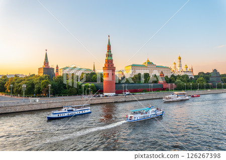 View of Kremlin with Vodovzvodnaya tower, Grand Kremlin Palace from repaired Bolshoy Kamenny Bridge in Moscow city on sunny summer day. Cruise ship sails on the Moscow river 126267398