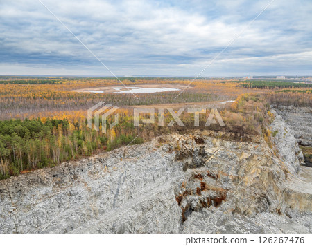 Stone quarry in the forest. Flying over the autumn mixed forest during sunset. The surroundings of Yekaterinburg. Ural, Russia, Aerial View 126267476