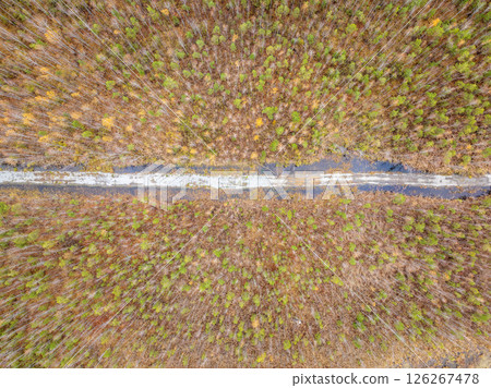 Aerial view of road in beautiful autumn forest at sunset. Beautiful landscape with empty rural road, trees with red and orange leaves. Aerial view of road in beautiful autumn forest at sunset. Beautiful landscape with empty rural road, trees with red and orange leaves. 126267478
