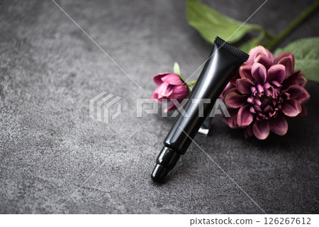Cosmetic black tube container and pink flowers 126267612
