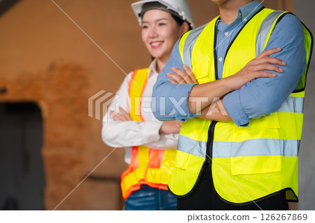 Successful engineer teams working together wear worker helmets hardhat on construction site. Successful engineer teams working together wear worker helmets hardhat on construction site. 126267869