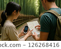 Talking while looking at a map and a translator on a bamboo forest path 126268416